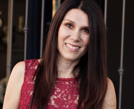 Headshot of Jenifer Merriam smiling in a red dress.
