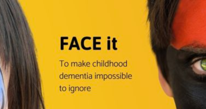 The background is bright yellow. On the left is a child with blue face paint. To the right is another child, who has red, white, and black face paint on, Between the children, the text reads, 'FACE it To make childhood dementia impossible to ignore'.